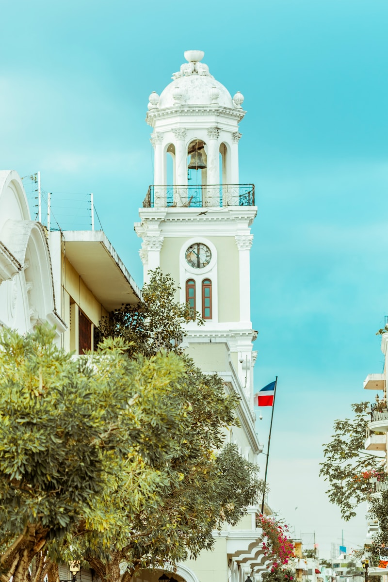 a tall white clock tower towering over a city